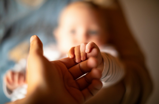 dłoń trzymająca noworodka